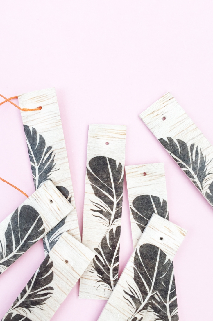 DIY Feather Wood Tags - Maritza Lisa: All you need is this free feather download, some balsa wood and printable tattoo paper to make these pretty tags. Click through for the tutorial....