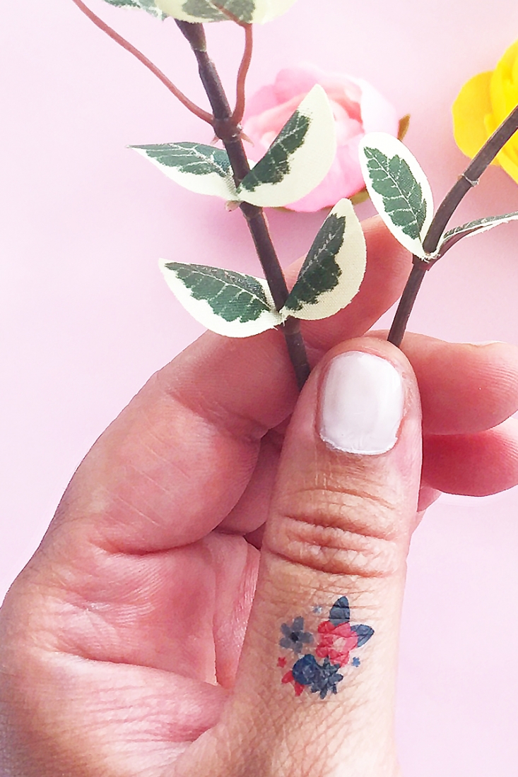 Minimalist flowers tattoo on the finger.